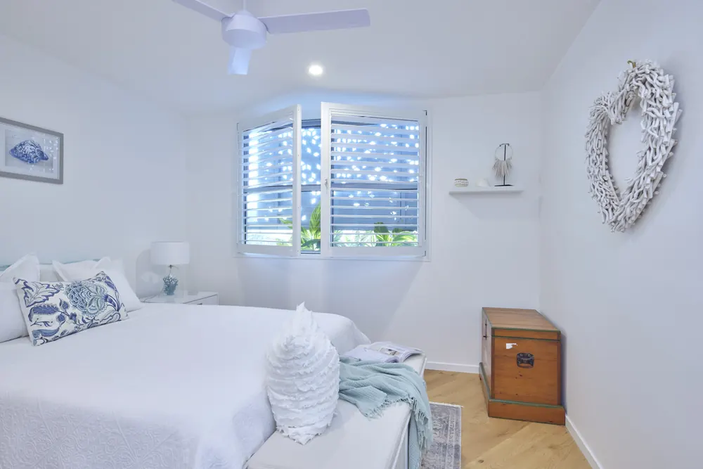A Brisbane bedroom with the Guardian shutters closed and the blades tilted shut