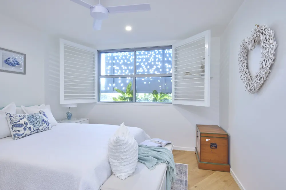 The same bedroom with the shutters swung open to the window